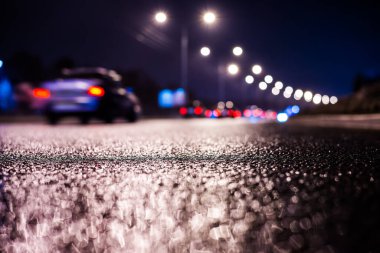 Büyük şehirde yağmurlu bir gece, su birikintileri olan boş bir yol.