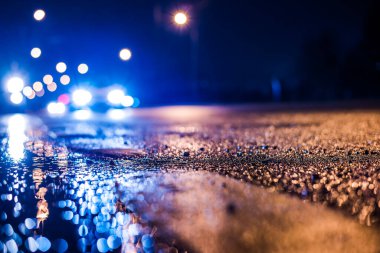 Büyük şehirde yağmurlu bir gece, su birikintileri olan boş bir yol.