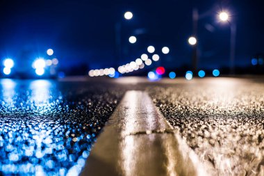 Büyük şehirde yağmurlu bir gece, su birikintileri olan boş bir yol.