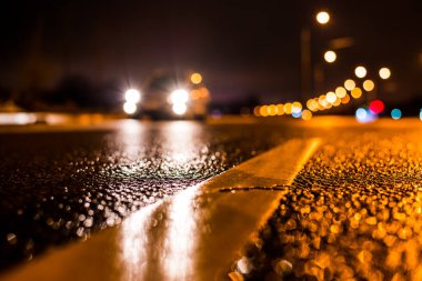 Büyük şehirde yağmurlu bir gece, su birikintileri olan boş bir yol.