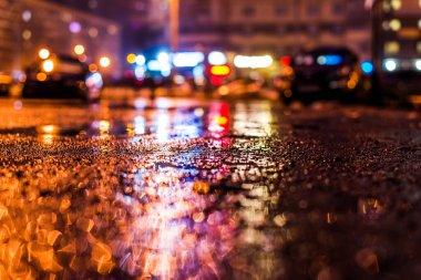 Büyük şehirde yağmurlu bir gece, su birikintileri olan boş bir yol.