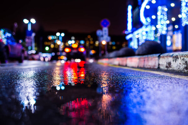 Rainy night in the big city, the empty road with puddles