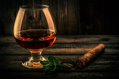 Nane filizi ve ahşap kalaslı bir bardak brendi.