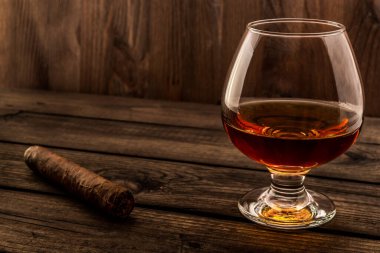 Bardak brendi ve puro eski ahşap masa. 