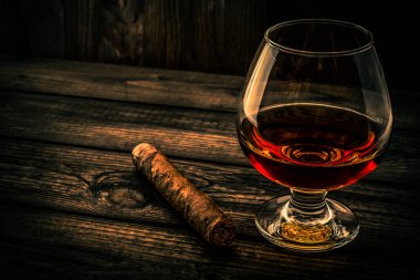 Bardak brendi ve puro eski ahşap masa. 