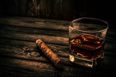 Bardak brendi ve puro eski ahşap masa.