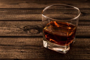 Glass of brandy and on an old wooden table.