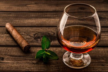 Nane filizi ve ahşap kalaslı bir bardak brendi.