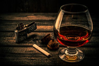 Eski ahşap bir masada bir bardak brendi ve çikolatalı trüf.. 