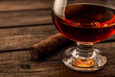 Bardak brendi ve puro eski ahşap masa. 