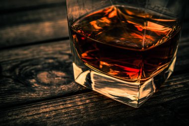 Glass of brandy and on an old wooden table. 
