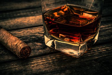 Bardak brendi ve puro eski ahşap masa.