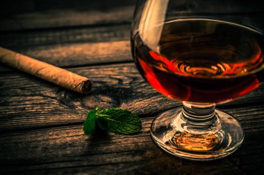 Nane filizi ve ahşap kalaslı bir bardak brendi.