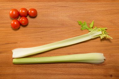 Tahta bir masada kerevizli domates ve marul.