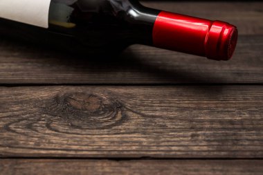 Bottle of red wine lying on an old wooden table.