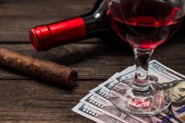 Bir şişe kırmızı şarap, bir kadeh kırmızı şarap ve Küba purosu.