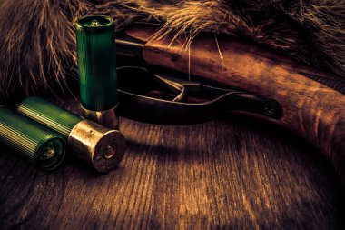 Hayvanın kürkünün yanında duran av tüfeği üretimi ve yeşil 