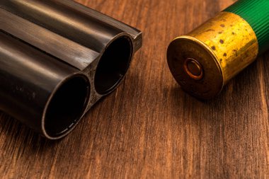 Çift namlulu av tüfeği namlusu ve yeşil fişek. Görüntüyü kapat
