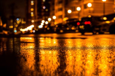 Büyük şehirde yağmurlu bir gece, fenerlerin ışığı