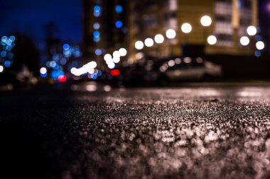 Büyük şehirde yağmurlu bir gece, fenerlerin ışığı