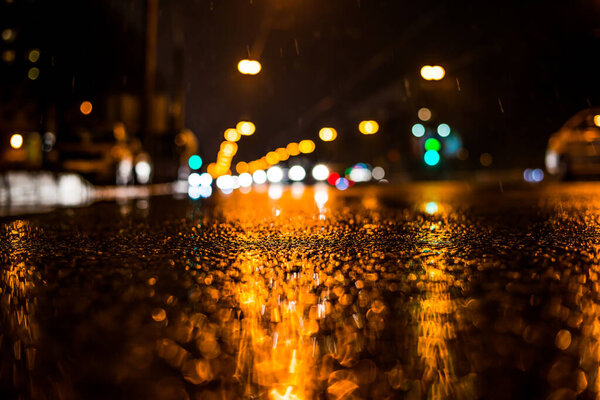 Дождливая ночь в большом городе, машины едут по мокрой дороге.