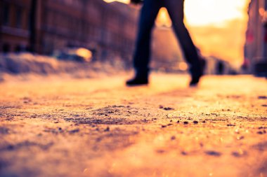 Büyük bir şehirde parlak kış güneşi, karlı caddede araba gidiyor.. 