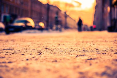 Büyük bir şehirde parlak kış güneşi, karlı caddede araba gidiyor.. 