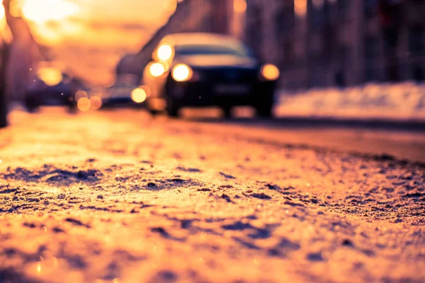 大都市の明るい冬の太陽雪の通りに車で行く — ストック写真