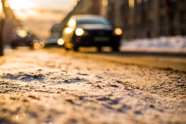 大都市の明るい冬の太陽雪の通りに車で行く — ストック写真
