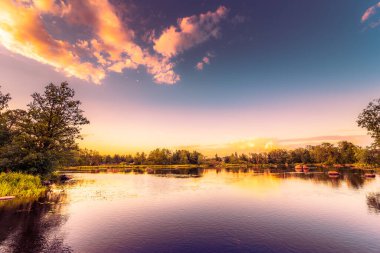 Ormandaki sessiz göl batan güneşin ışığı altında.