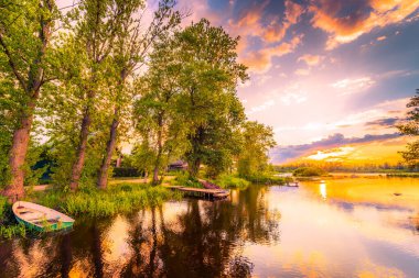 Gölün üzerinde gün batımı, köprüden rıhtıma ve eve manzara