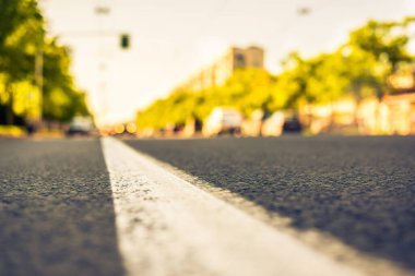 Şehirde güneşli bir gün, yol kenarına yaklaşan otobüsün manzarası