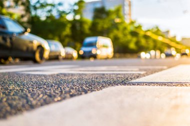 Şehirde güneşli bir gün, yaya geçen arabaların manzarası.