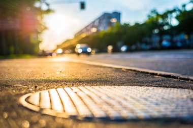 Şehirde güneşli bir gün, kapağın kaldırım seviyesinden manzara