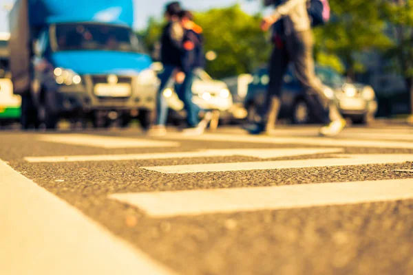 stock image Sunny day in a city, pedestrians crossing the road. View from th