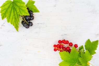 Kırmızı üzümler ve siyah üzümler eski ahşap masada.