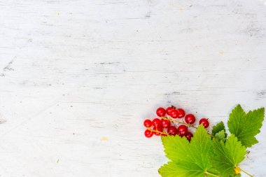 Eski ahşap masada kırmızı frenk üzümü