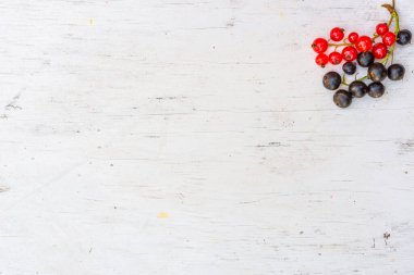 Kırmızı üzümler ve siyah üzümler eski ahşap masada.