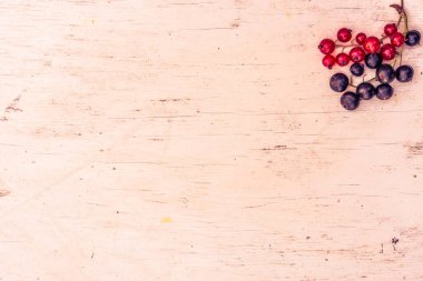 Kırmızı üzümler ve siyah üzümler eski ahşap masada.