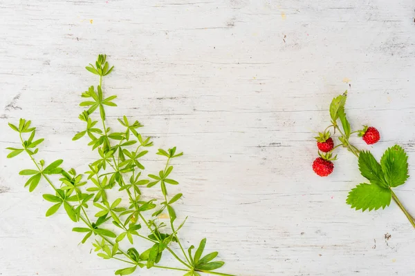 Strawberry with grass on old wooden table