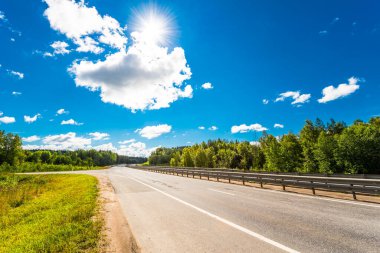 Kırsal yol tarlalardan ve ağaçlardan geçiyor.