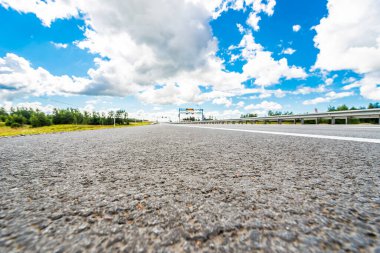 Kırsal yol bir benzin istasyonunun yanından geçiyor. Yol seviyesinden görüntüle