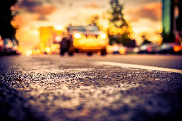 Sun after the rain in the city, view of the approaching car with