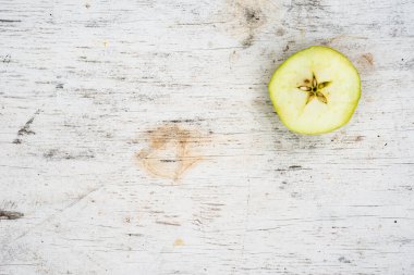 Eski ahşap masada yarım elma