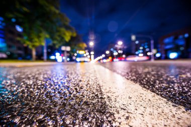 Gece gündüz yağmur yağıyor, yaklaşan otobüsün parlayan ışıkları. Vi