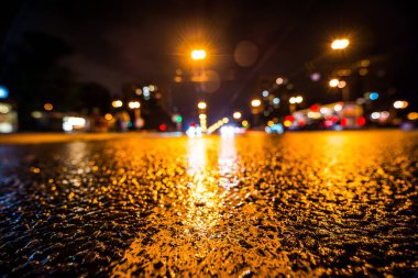 Gece gündüz yağmur yağıyor, yaklaşan arabaların parlayan ışıkları. Çeviri: