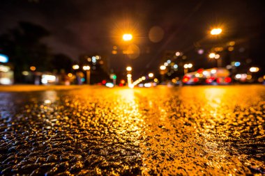 Gece gündüz yağmur yağıyor, yaklaşan arabaların parlayan ışıkları. Çeviri: