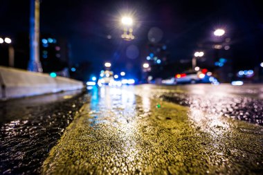 Gece gündüz yağmur yağıyor, yaklaşan arabaların parlayan ışıkları. Çeviri: