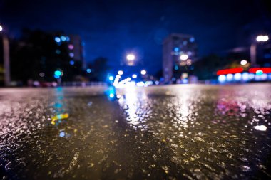 Gece gündüz yağmur yağıyor, yaklaşan arabaların parlayan ışıkları. Çeviri: