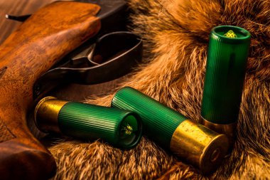 Hayvanın kürkünün yanında duran av tüfeği üretimi ve yeşil 